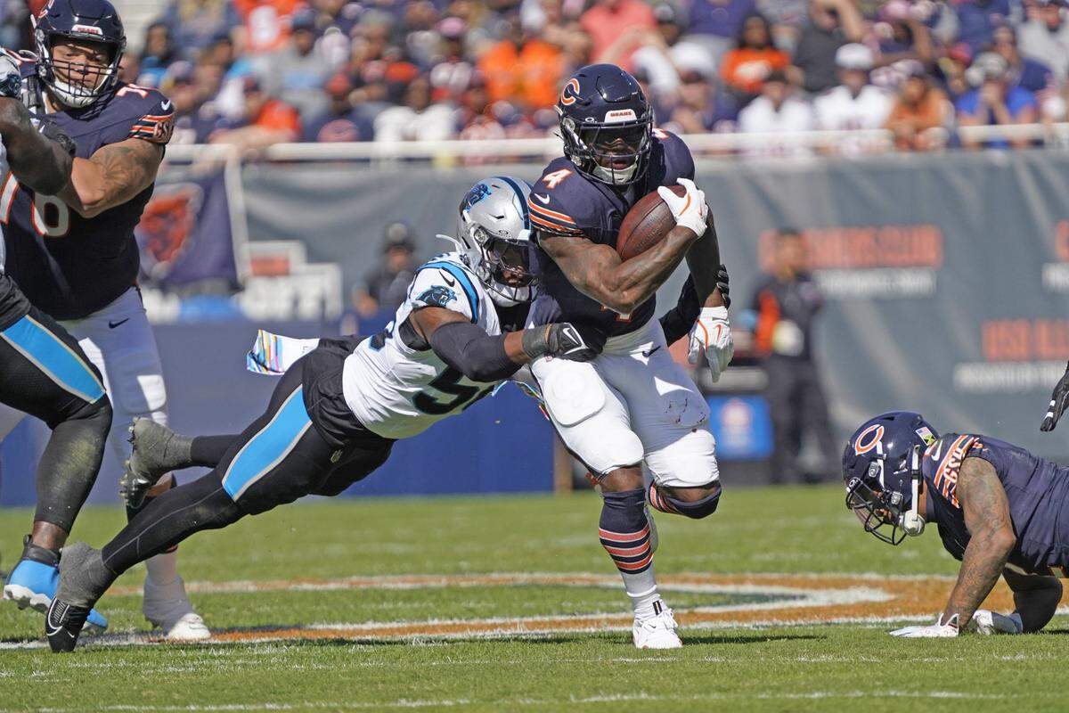 Oct 6, 2024; Chicago, Illinois, USA; Chicago Bears running back D’Andre Swift (4) runs the ball as Carolina Panthers linebacker Trevin Wallace (56) tackles him during the first half at Soldier Field. Mandatory Credit: David Banks-Imagn Images