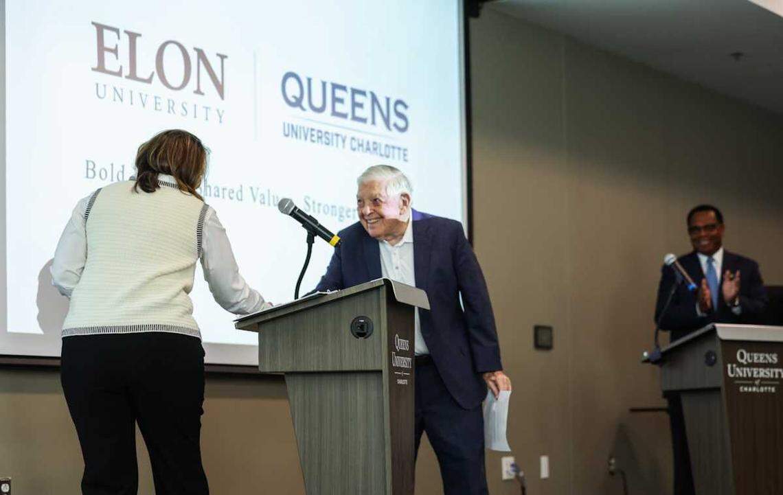 Elon President Connie Book shakes hands with Hugh McColl after the announcement of the merger of Queens and Elon universities.