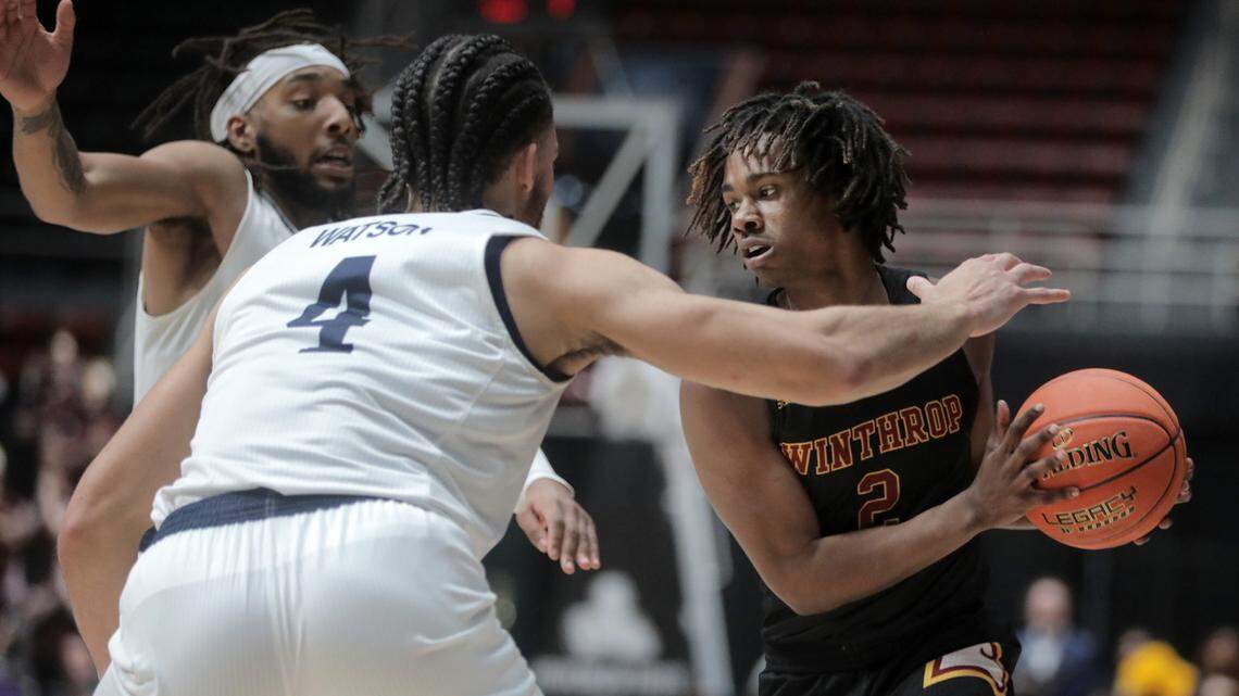 Winthrop’s Sin’Cere McMahon looks for an opening around Longwood’s Zac Watson (4) and Jordan Perkins.