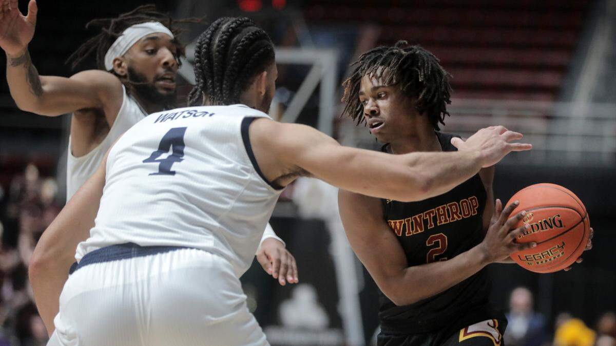 Winthrop’s Sin’Cere McMahon looks for an opening around Longwood’s Zac Watson (4) and Jordan Perkins.