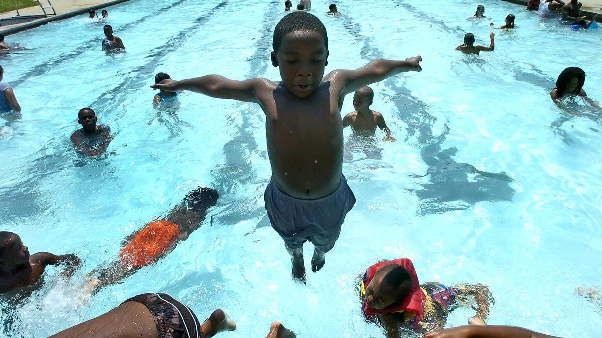 Armani Frazier, 7, takes a dive into the Cordelia Pool in NoDa on Thursday, August 9, 2007. - YALONDA M. JAMES - yjames@charlotteobserver.com