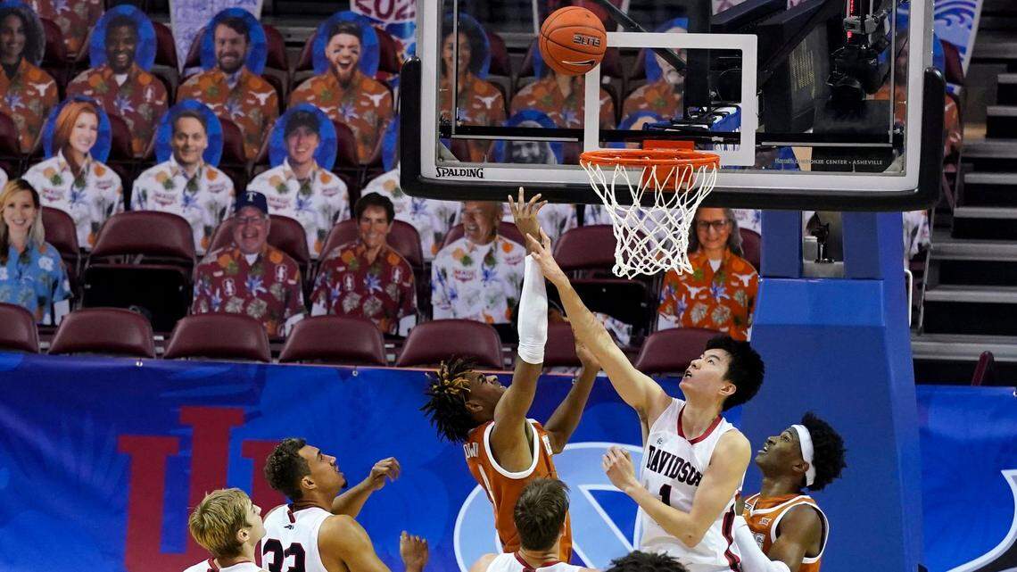 Davidson forward Hyunjung Lee (1) leaps past Texas forward Kai Jones (22) to try to block a shot by Texas forward Greg Brown (4) in the second half of an NCAA college basketball game in the Maui Invitational tournament, Monday, Nov. 30, 2020 in Asheville, N.C. The stands were empty of fans and were replace by cut outs. Texas won 78-76. (AP Photo/Kathy Kmonicek)