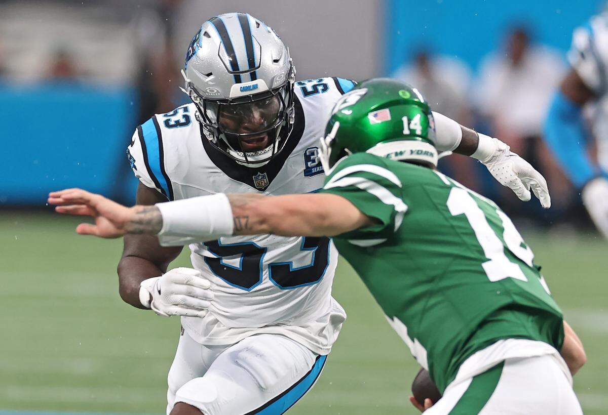 Carolina Panthers linebacker Claudin Cherelus, left, looks to make the tackle on New York Jets quarterback Andrew Peasley, right, on a run during first quarter action at Bank of America Stadium in Charlotte, NC on Saturday, Aug. 17, 2024. 