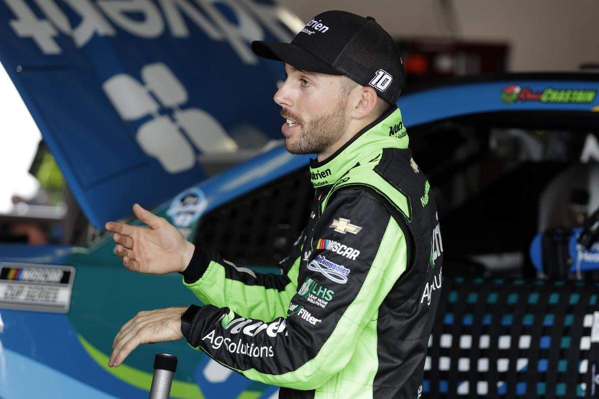NASCAR driver Ross Chastain talks to crew members after a practice run for the Daytona 500 in February.