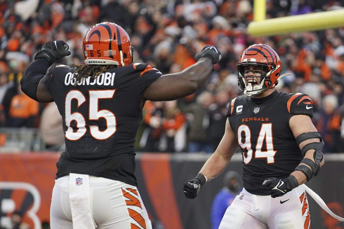 Cincinnati Bengals’ Sam Hubbard (94) celebrates with Larry Ogunjobi (65) during the first half of an NFL wild-card playoff football game between Cincinnati and the Las Vegas Raiders on Saturday, Jan. 15, 2022, in Cincinnati.
