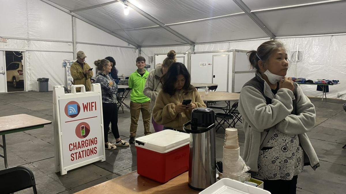 On Cayte Gowan’s last night serving food at the Owen Pool Comfort Station in Swannanoa, people wait in line for something to eat.