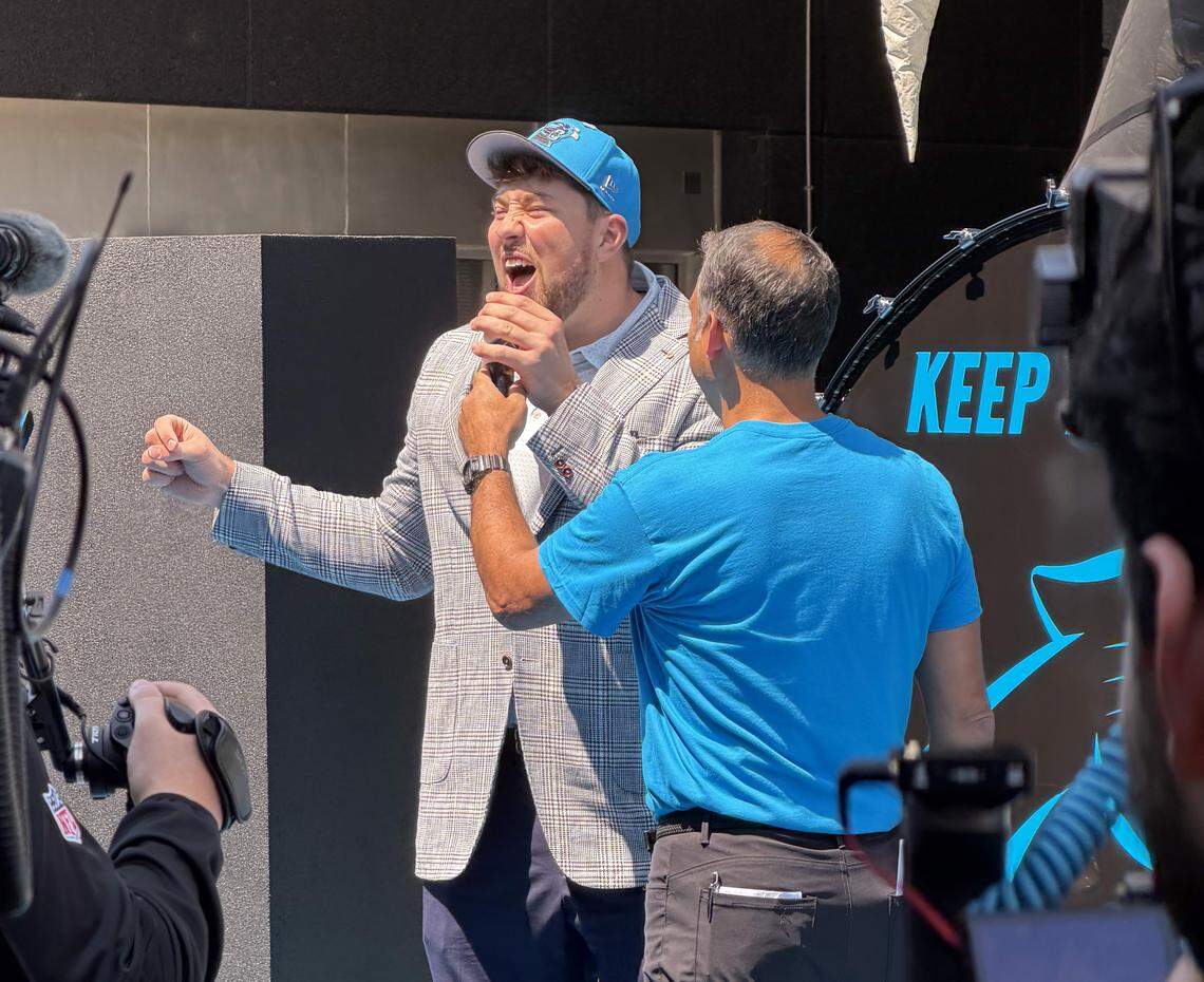 Carolina’s first-round draft pick Monroe Freeling, left, pumps up the crowd at Bank of America Stadium after arriving in Charlotte on Friday.