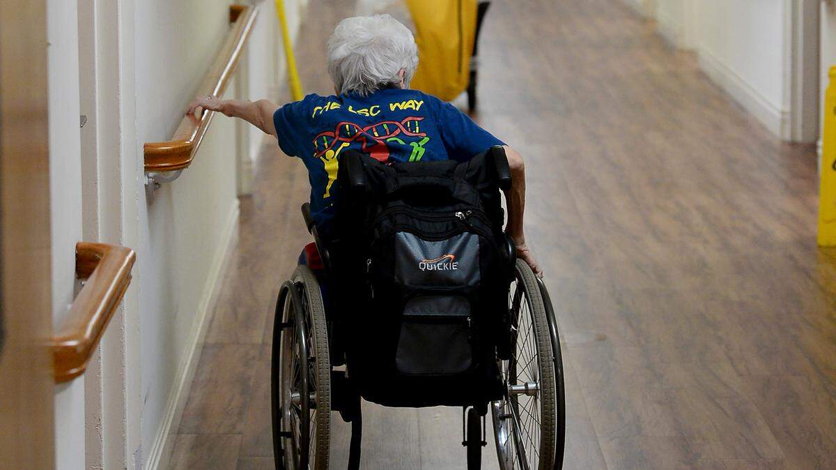 A resident of Trinity Oaks nursing home in Salisbury makes her way down a hallway on Friday, January 28, 2022.