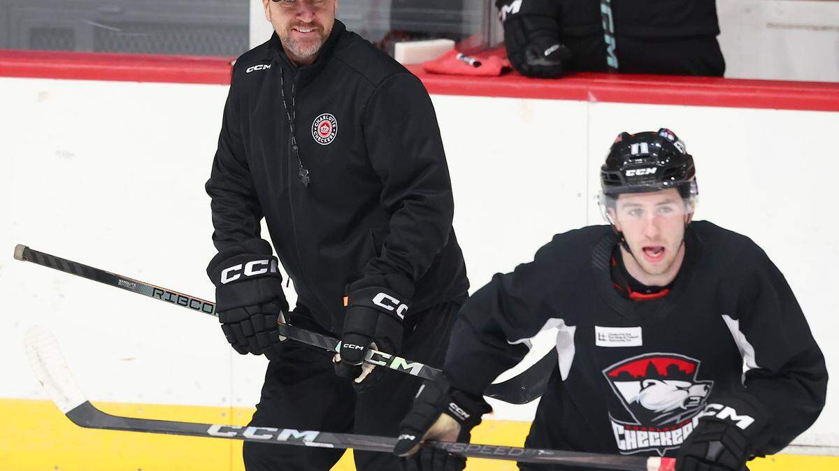 Charlotte Checkers head coach Geordie Kinnear, left, smiles as he watches his team run through drills during practice at BoJangles Coliseum in Charlotte, NC on Thursday, October 9, 2025.