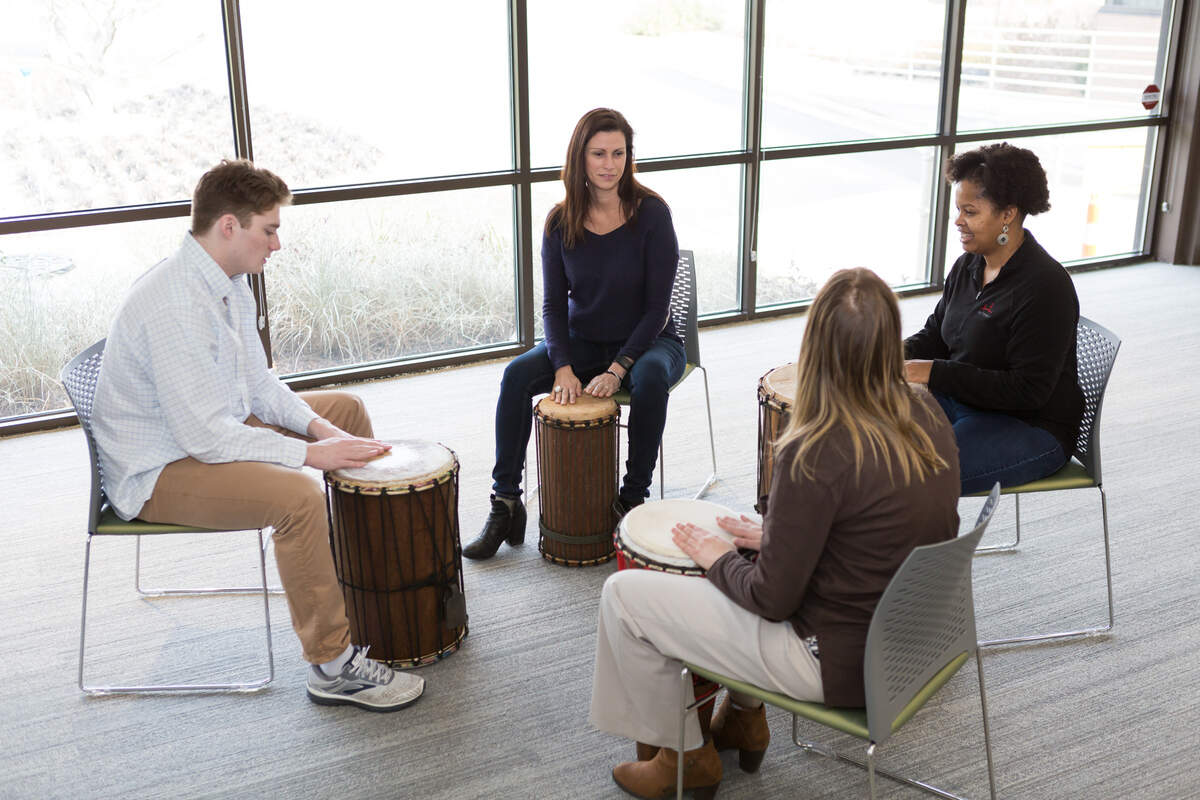 Joan Kleinmann, center, leads a group at HopeWay through a music therapy program with drums.