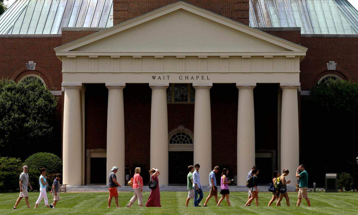 A group walks across the lawn on the campus of Wake Forest University in Winston-Salem, N.C. Wednesday, May 28, 2014. (AP Photo/Gerry Broome)