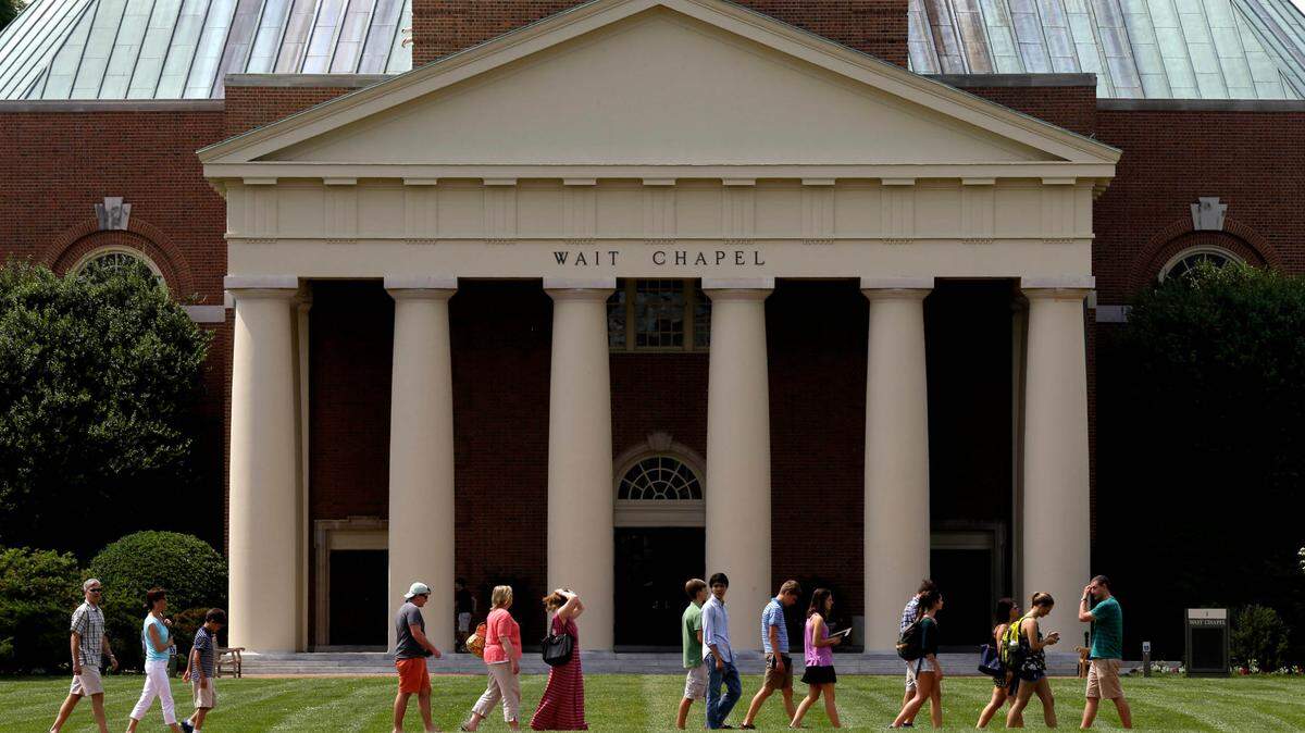A group walks across the lawn on the campus of Wake Forest University in Winston-Salem, N.C. The school announced in an advisory that there are three reports of drugs found in alcoholic drinks.