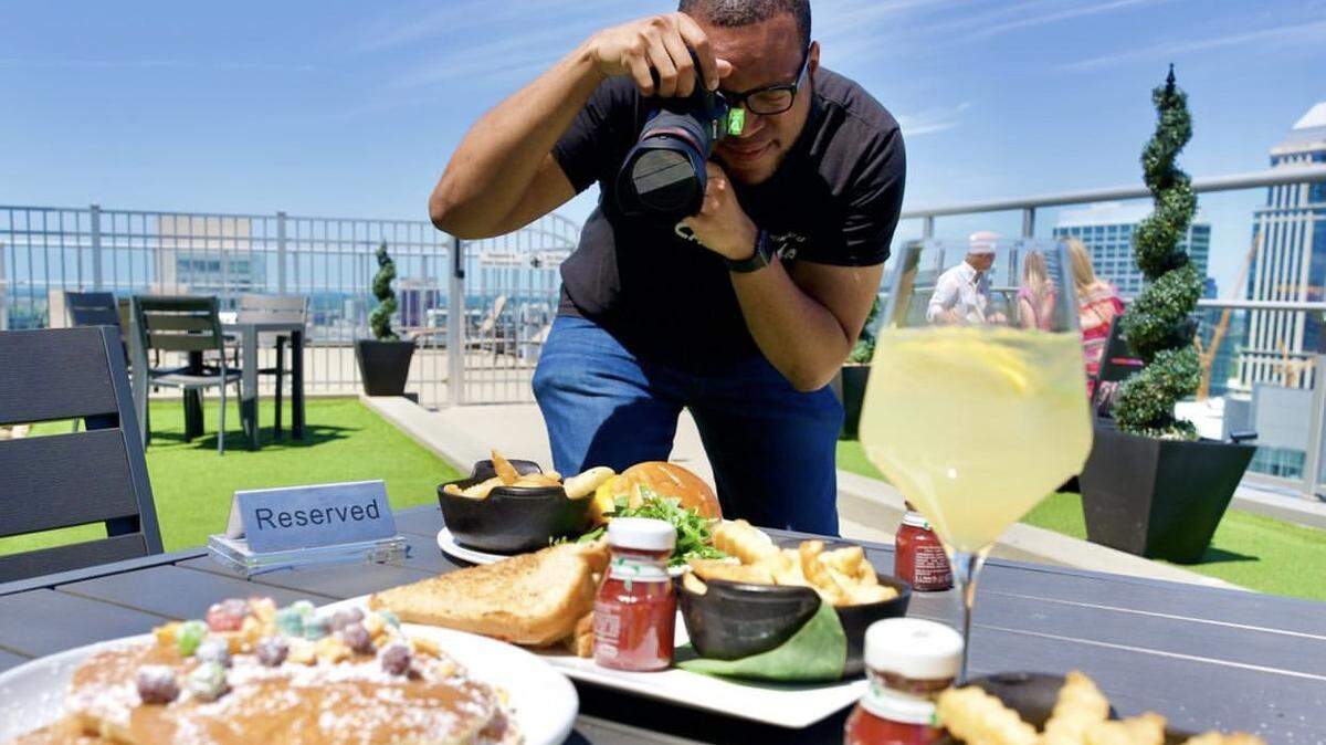 Cory Wilkins photographs dishes at Fahrenheit, a rooftop bar in uptown Charlotte.