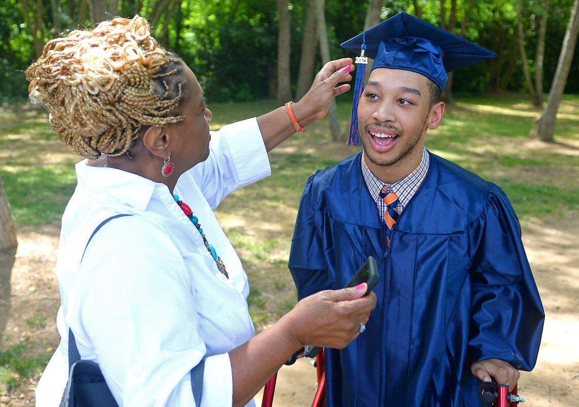 Saundra Adams, left, adjusts the 2021 tassel on Chancellor Lee Adams’ graduation mortarboard on Monday. Chancellor Lee will be graduating from Vance High School in June. He is the son of Cherica Adams and former Carolina Panthers wide receiver Rae Carruth.