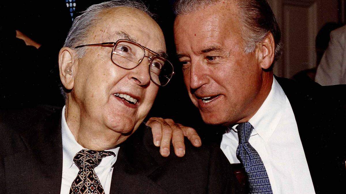 Republican Jesse Helms and Democrat Joe Biden share a moment in the Senate in this undated photo.