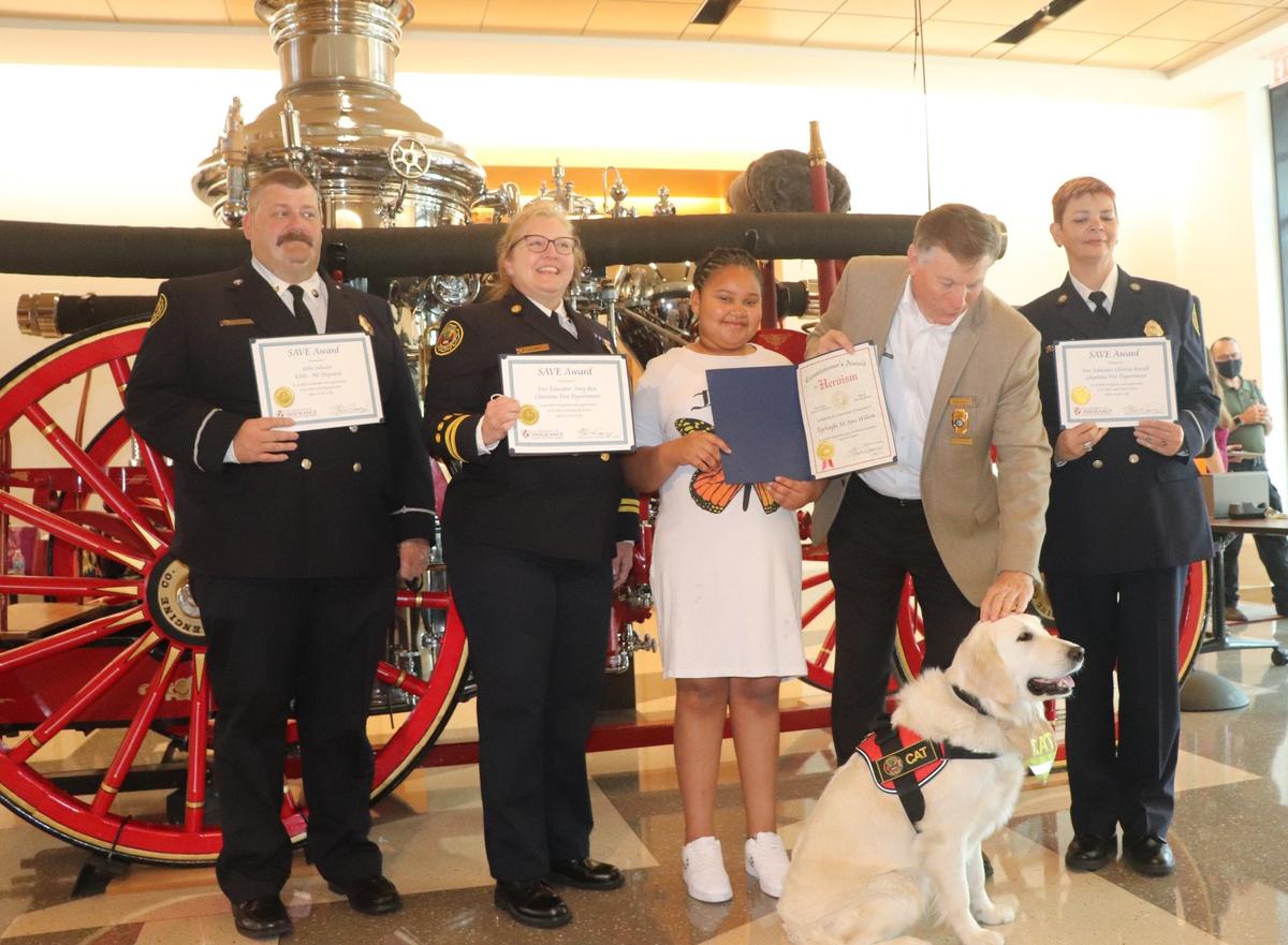 John Schuler (left), a Charlotte Fire Department 911 dispatcher, and Tyshala Wilson (center) received special honors for their efforts during an apartment fire in 2021.