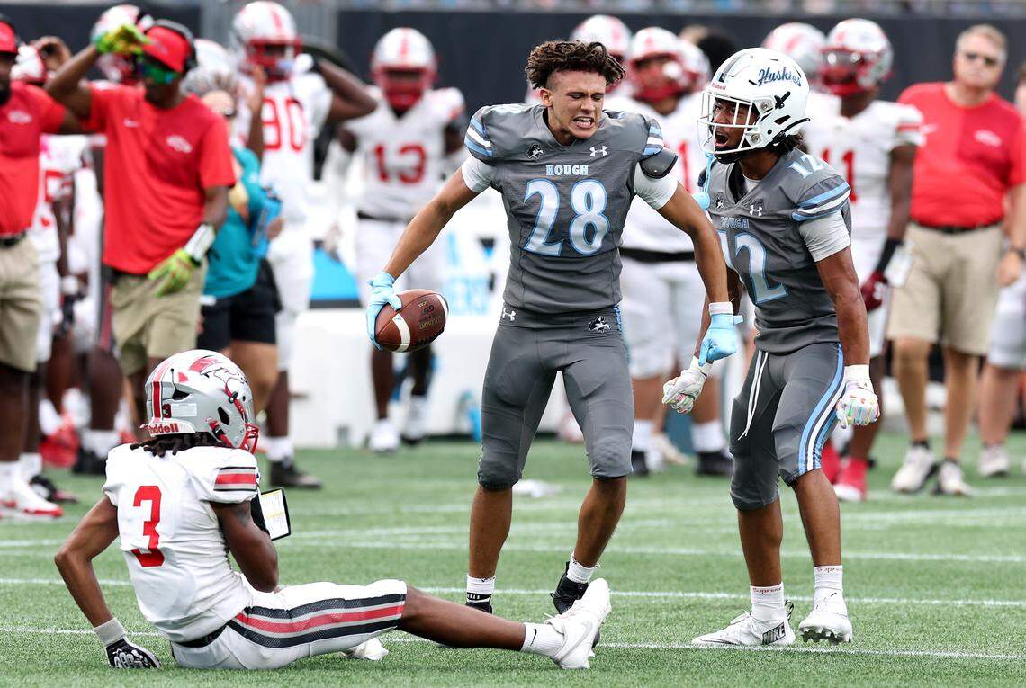 Hough Huskies defensive back Drew Johnson, center, celebrates his interception of a pass by South Pointe Stallions quarterback J’Zavien Currence during the Keep Pounding Classic at Bank of America Stadium in Charlotte, NC on Friday, August 22, 2025.