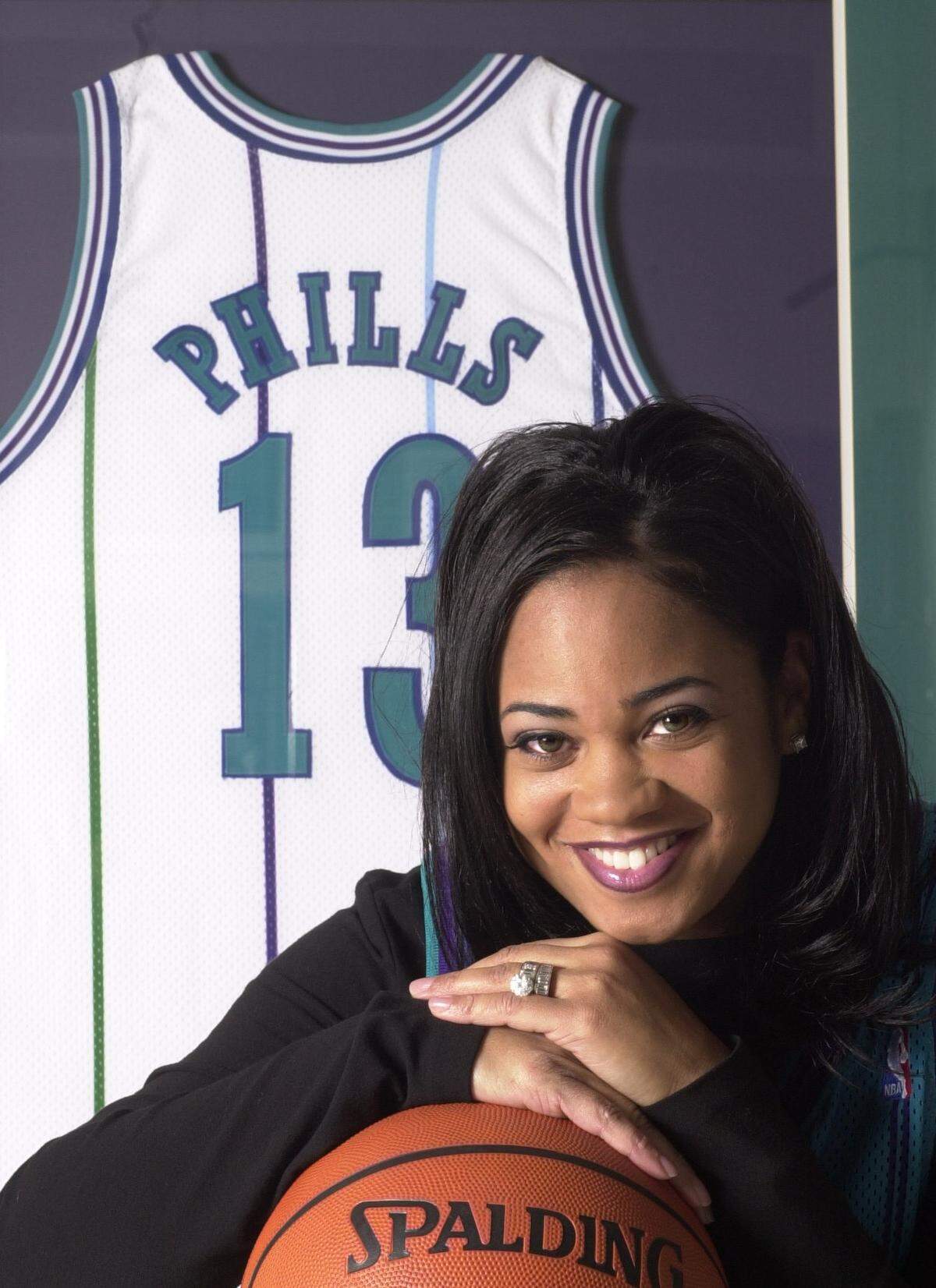 A photo taken in 2001 of Kendall Phills, in front of the jersey of her deceased husband, Bobby.