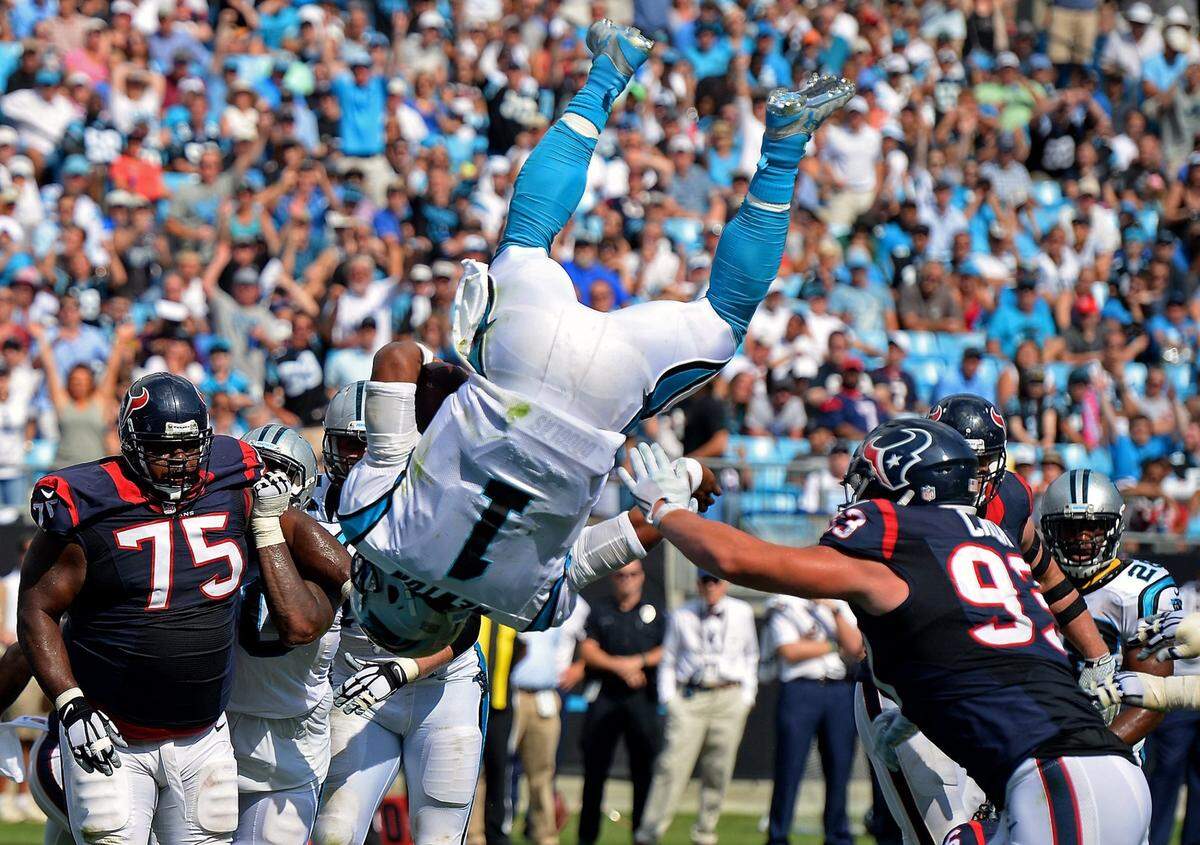 Carolina Panthers quarterback Cam Newton flips through the air over the goal line for a touchdown against Houston on Sept. 20, 2015.