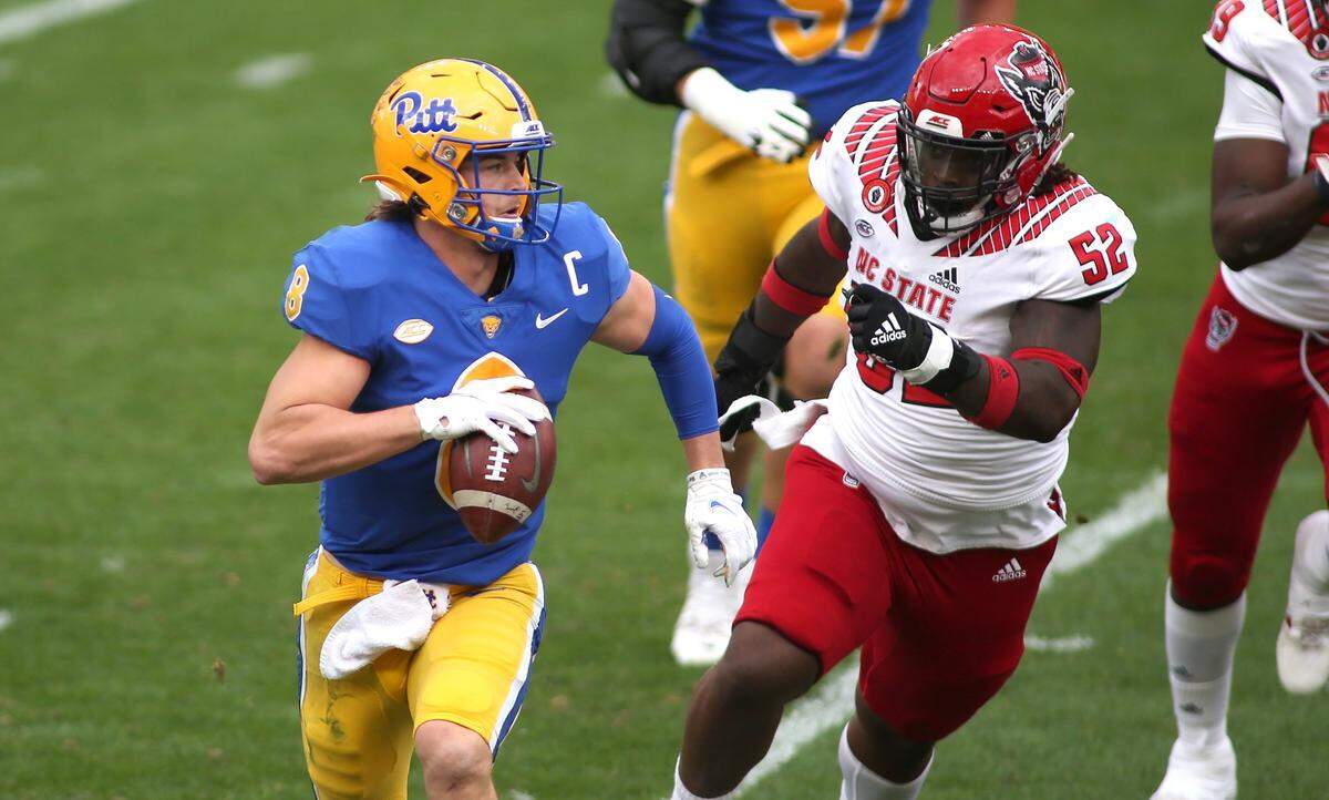 PITTSBURGH, PA - OCTOBER 03: Kenny Pickett #8 of the Pittsburgh Panthers attempts to avoid C.J. Clark #52 of the North Carolina State Wolfpack during the second half at Heinz Field in Pittsburgh, PA on October 3, 2020. (Photo by Michael Longo/Icon Sportswire)