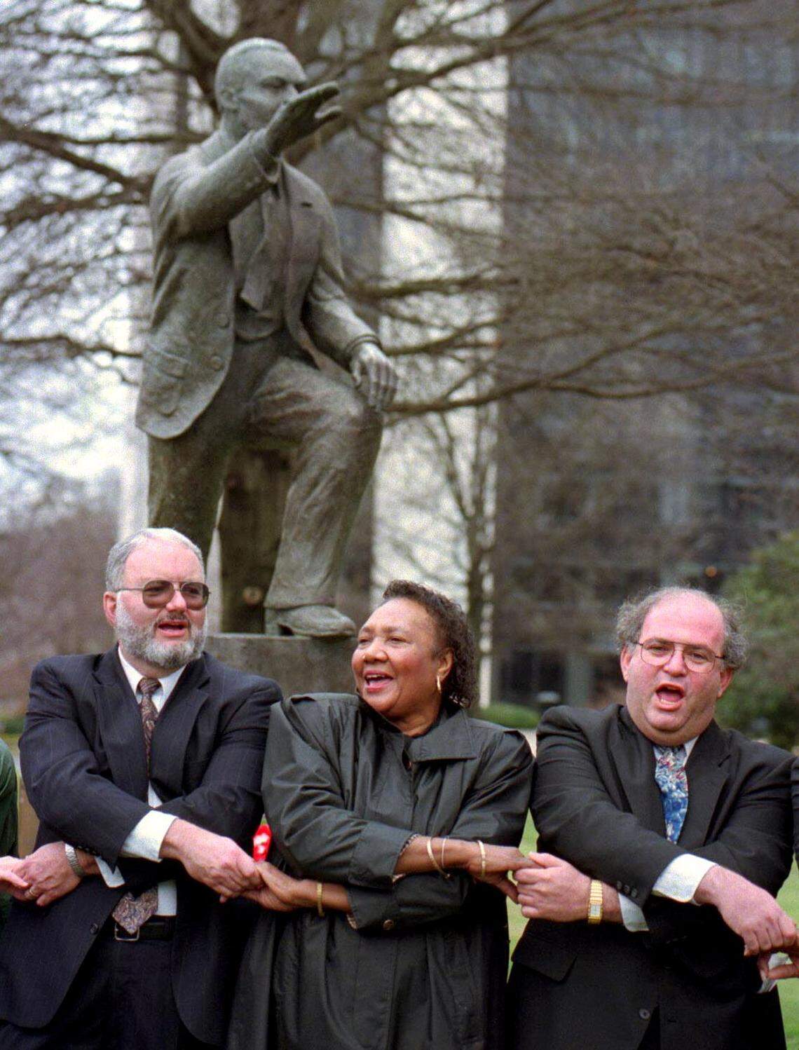 The Rev. Joseph McCutchen, left, Sarah Stevenson, center, and Rabbi Murray Ezring sing ``We Shall Overcome’’ during a service for Dr. Martin Luther King Jr. on Sunday Jan. 15, 1995 at Charlotte’s Marshall Park.