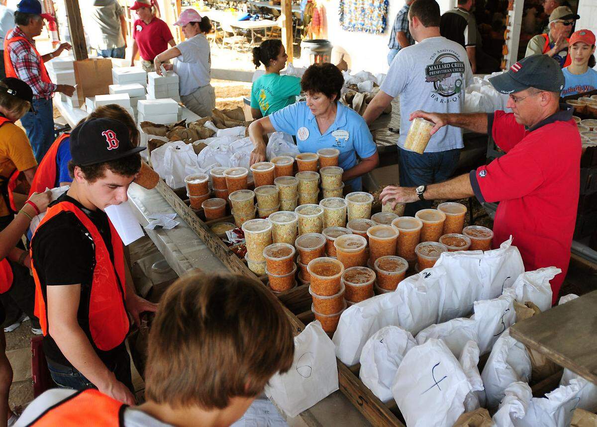 Volunteers organize and stack cole slaw, Brunswick stew and other items in the the drive through area during the 81st Mallard Creek Barbecue Thursday, Oct. 28, 2010. 