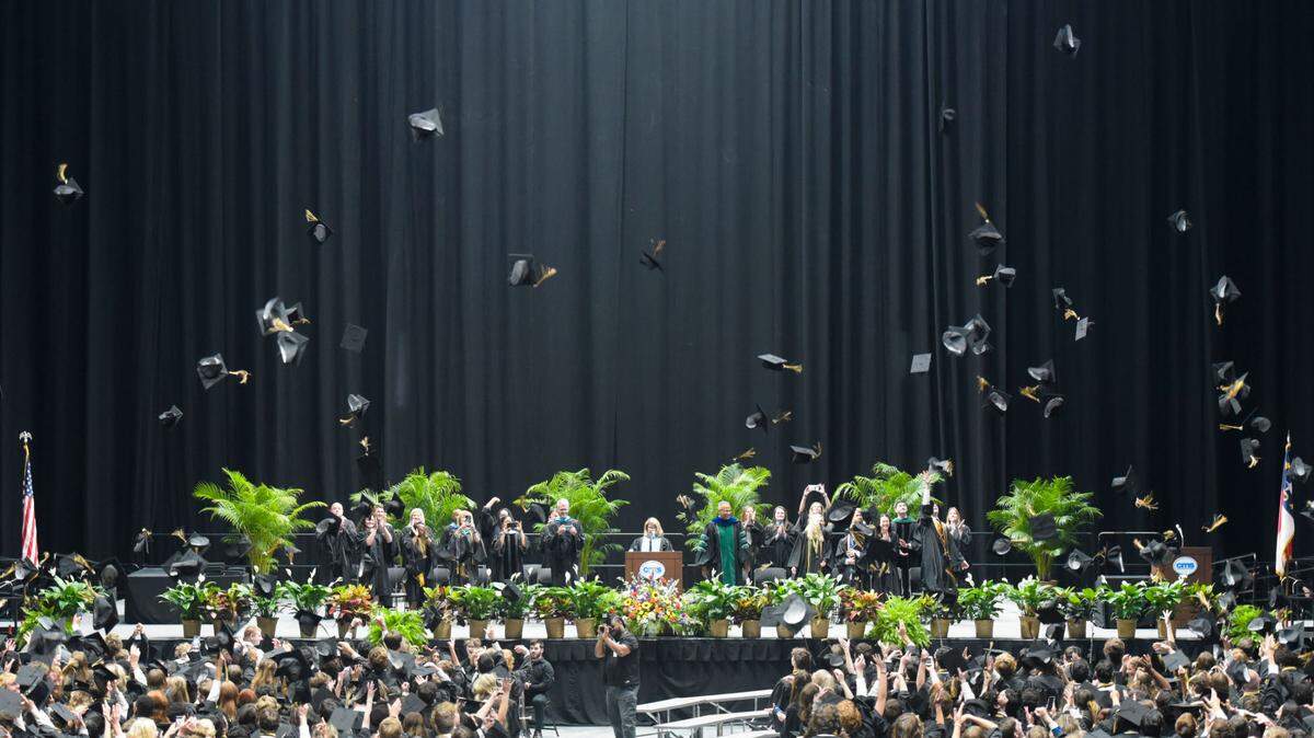 Providence High School graduates throw their mortarboards into the air moments after officially graduating High School on Wednesday, June 14, 2023, at Bojangles Coliseum.