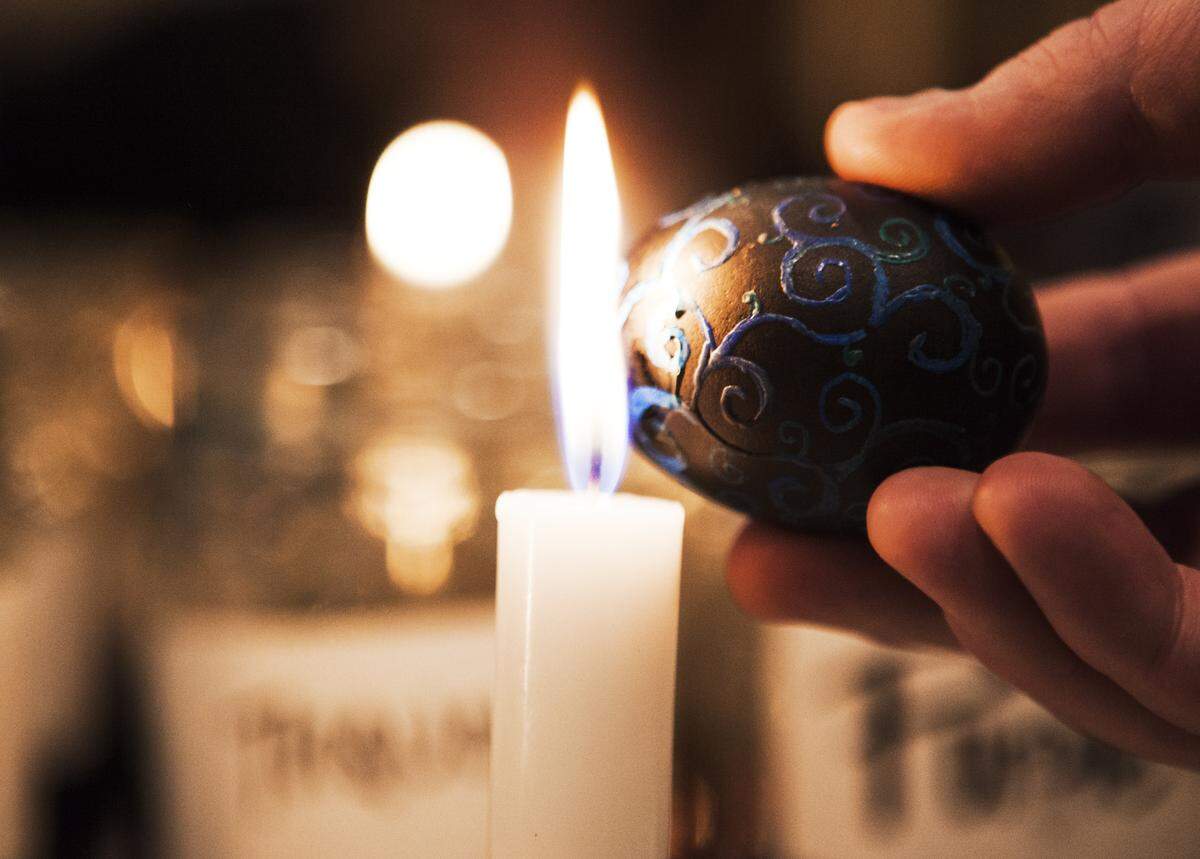 Wax is melted off a Ukrainian Easter egg to reveal the colorful pattern.