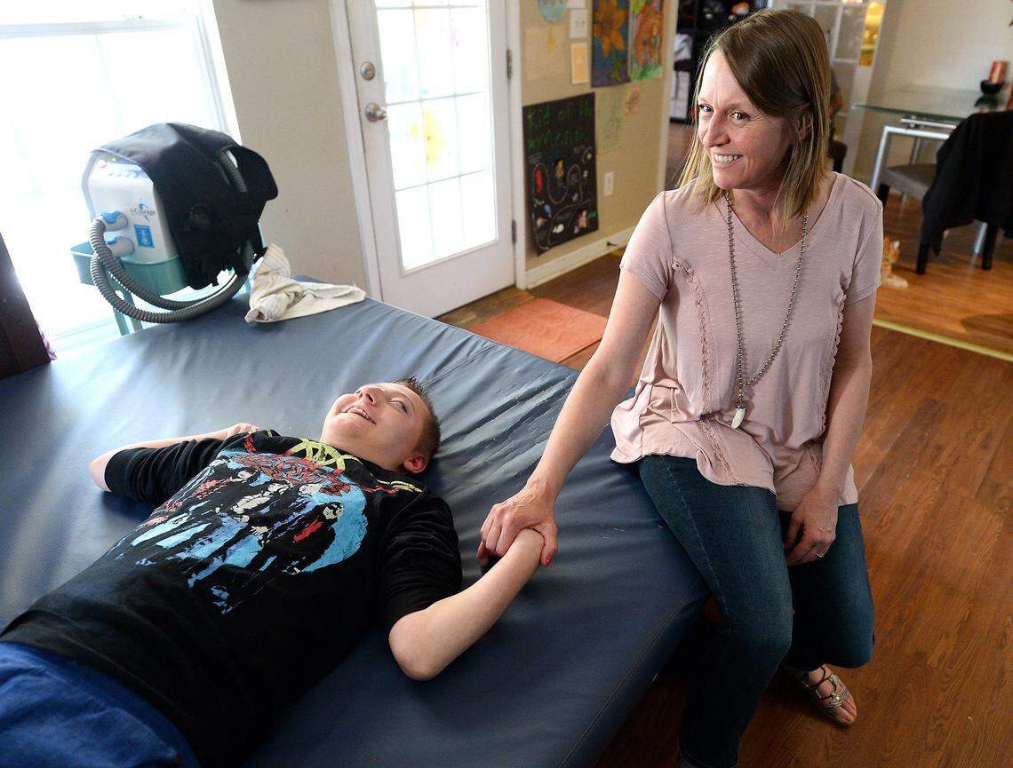 Kelly Helms, with her son, Jackson Helms, 19, on Tuesday, April 17, 2018. Jackson was supposed to have died at age 6 because of complications he has. Jackson has cerebral palsy and Lennox-Gastaut syndrome, a form of severe epilepsy that can resist treatment and caused him to have up to 15 seizures a day. Since CBD was legalized, his seizures have largely gone away, his mom says. Still, the Helms family supports legalizing medical marijuana because the THC component can help pull their son out of seizure comas when they happen.