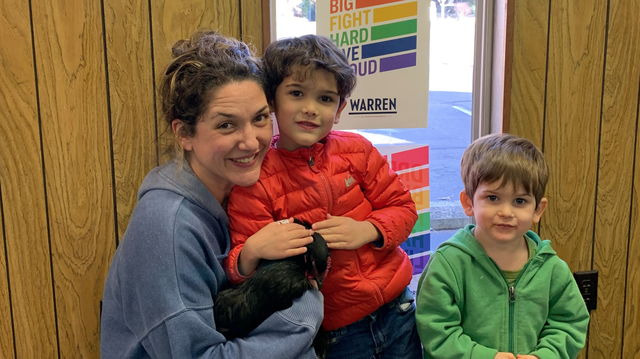 Three people pose with a chicken that got into a campaign office for Elizabeth Warren, officials say.