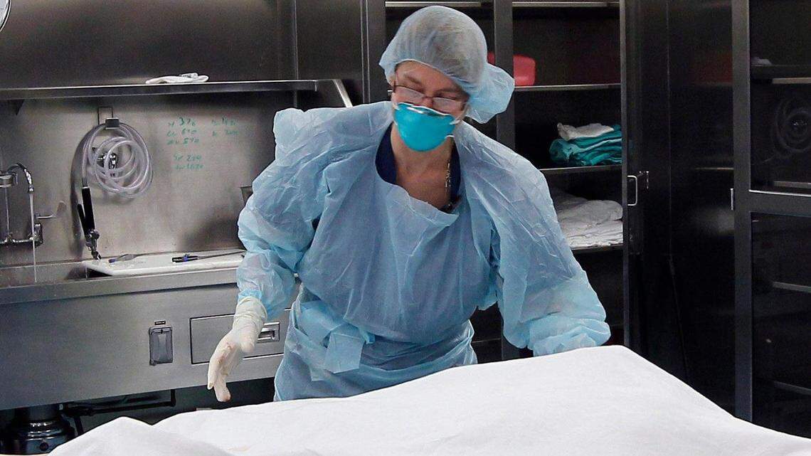 In this file photo from 2014, autopsy technician Judith Page cleaned up after performing an autopsy at the North Carolina Office of the Chief Medical Examiner in Raleigh.