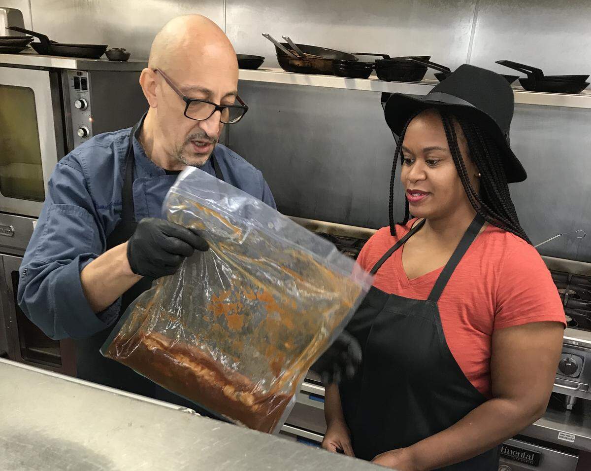 Chef Kamel Dahmani shows CharlotteFive writer DeAnna Taylor how he prepares the Charlotte City Club’s slow-cooked short ribs.