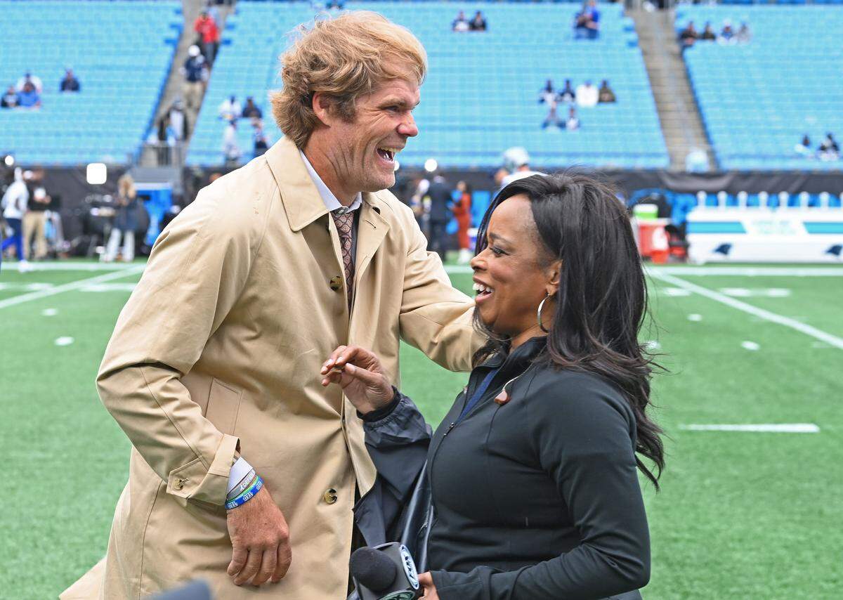 FOX Sports analyst Greg Olsen, left, enjoys a laugh with sideline reporter Pam Oliver, right, prior to the Carolina Panthers vs Dallas Cowboys game at Bank of America Stadium on Sunday, October 12, 2025. Oliver is the longest tenured NFL sideline reporter with more than 500 games.