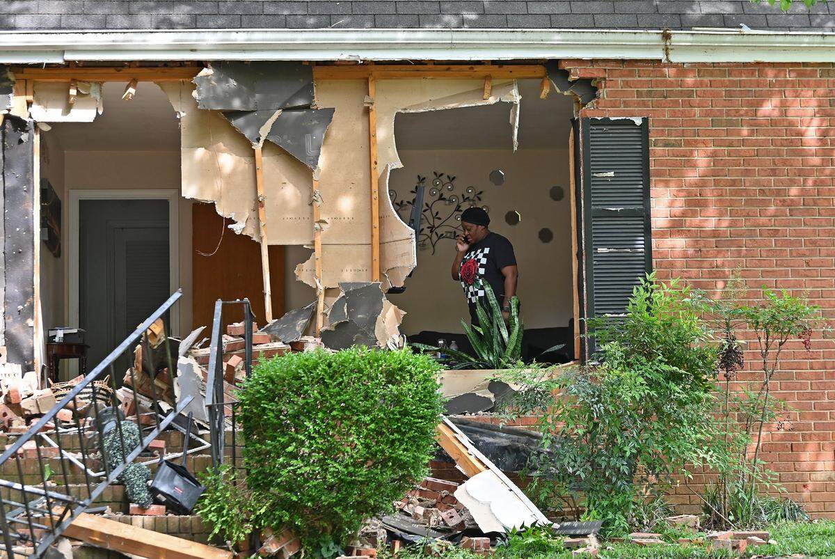 A woman claiming to be the sister of the owner of the home at 5525 Galway Drive stands in a front room on Tuesday, April 30, 2024. The home is the site where three members of the U.S. Marshals task force and a CMPD Officer Joshua Eyer were killed on Monday, April 29, 2024 when they were serving a warrant to the suspect. Four other officers were wounded during the shooting.