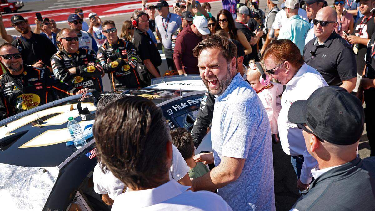 Vice Presidential Nominee Senator JD Vance, center, laughs with Donald Trump Jr., back to camera, along pit road at Charlotte Motor Speedway prior to the running of the Bank of America Roval 400 on Sunday, October 13, 2024 in Concord, NC.