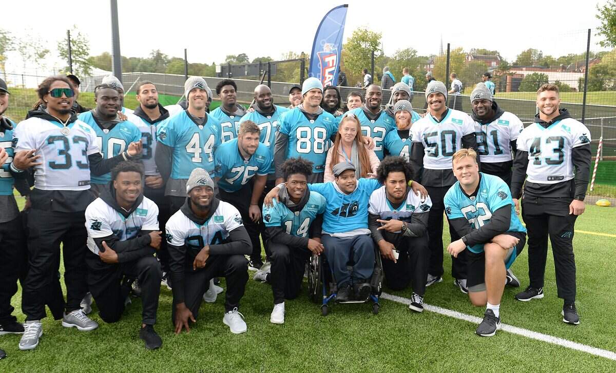 Carolina Panthers players pose with Joe Tucker-Lawrence, center/right, with the Harrow School Club following a NFL Play60 event with Harrow School students on Thursday, October 10, 2019 in London, England. The Panthers will face the Tampa Bay Buccaneers on Sunday, October 13, 2019.