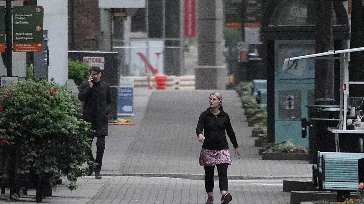 A pedestrian walks along a deserted sidewalk along Tryon Street in uptown Charlotte Tuesday morning, March 24, 2020.