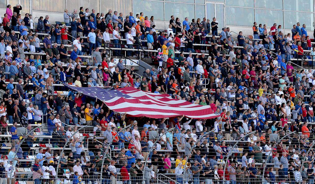 NASCAR fans honor America by holding a large flag in the front grandstand prior to the Coca-Cola 600 at Charlotte Motor Speedway on Sunday, May 30, 2021.