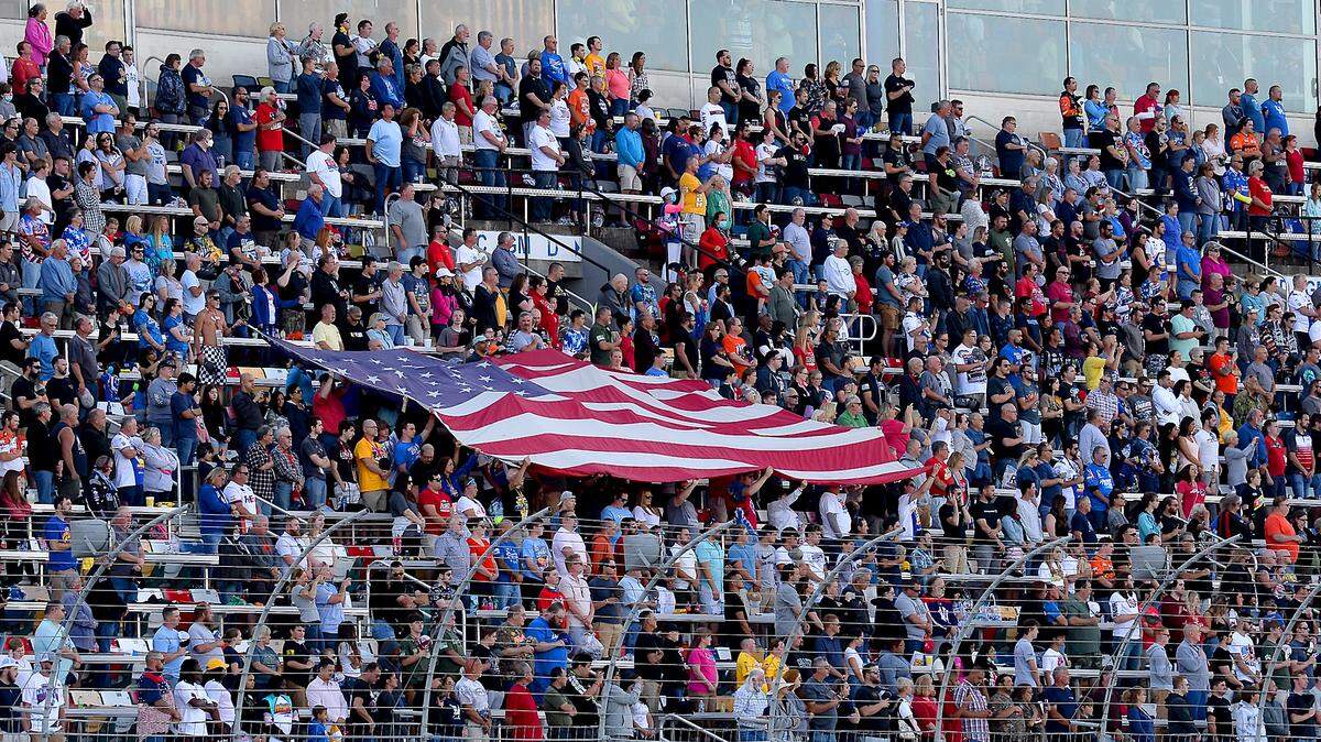 NASCAR fans honor America by holding a large flag in the front grandstand prior to the Coca-Cola 600 at Charlotte Motor Speedway on Sunday, May 30, 2021.