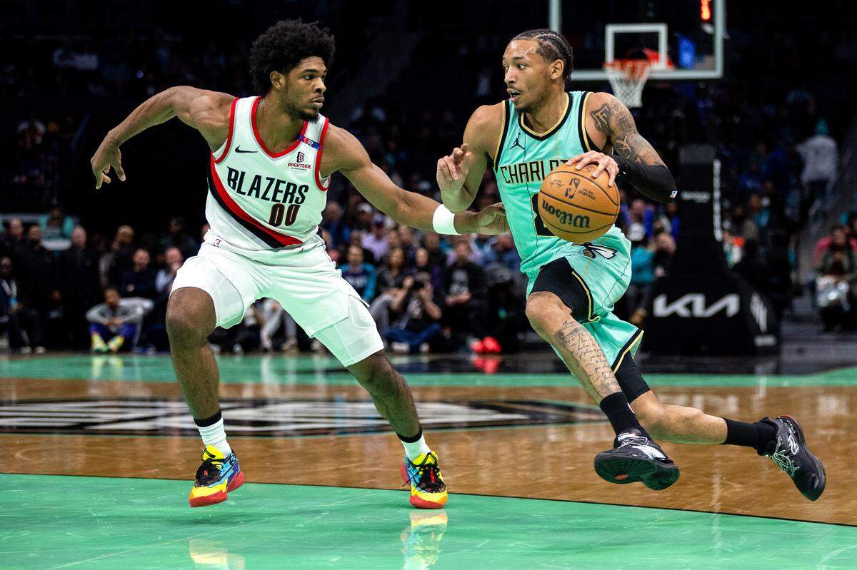 Charlotte Hornets guard Nick Smith Jr. (8) drives on Portland Trail Blazers guard Scoot Henderson (00) during the second quarter at Spectrum Center.