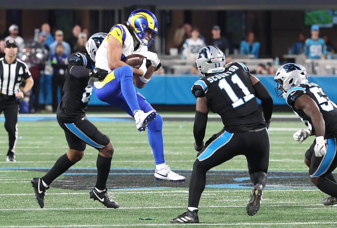 Los Angeles Rams wide receiver Puka Nacua, center, catches a pass over the middle as the Carolina Panthers defense converges during action at Bank of America Stadium on Saturday, January 10, 2026. The Rams defeated the Panthers 34-31.