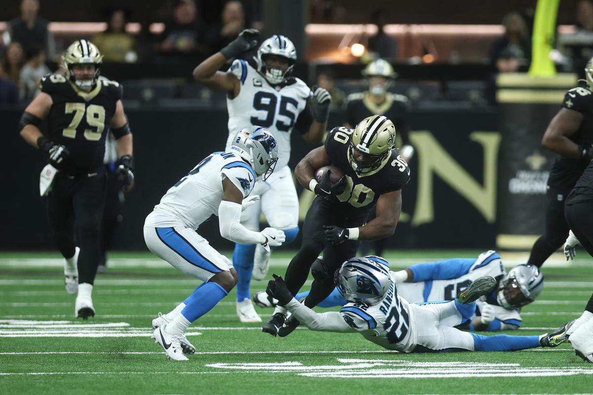 Lathan Ransom (22) of the Carolina Panthers tackles Audric Estime (30) of the New Orleans Saints during Sunday’s fourth quarter at Caesars Superdome.