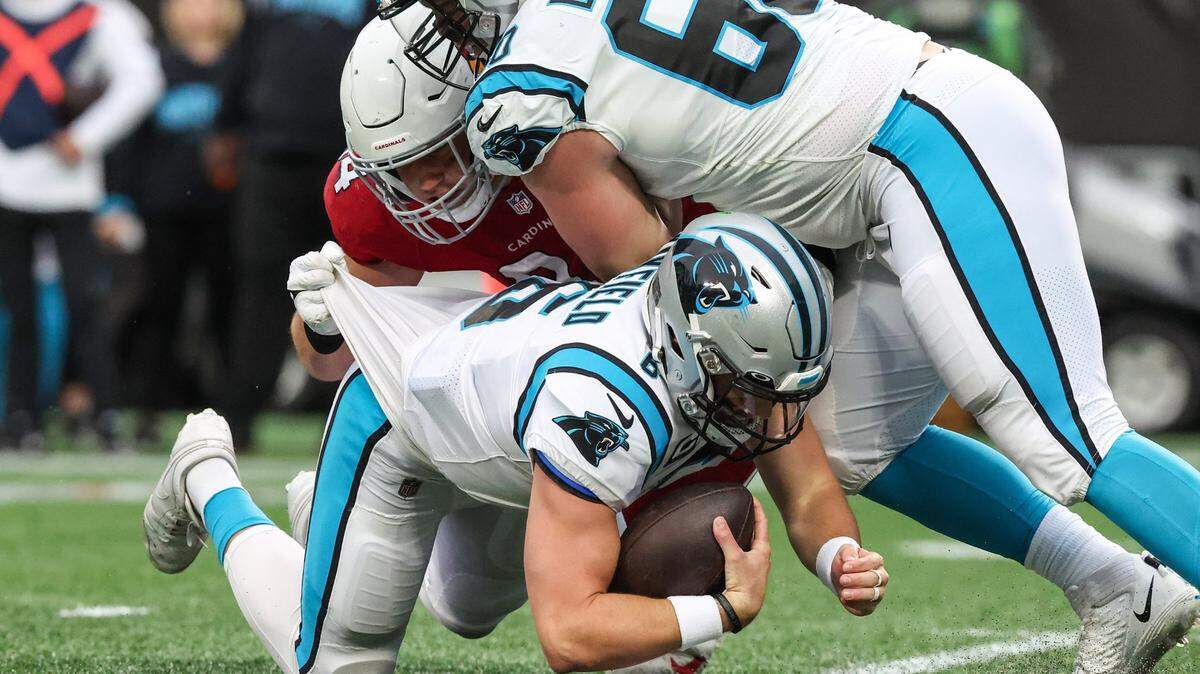 Cardinals defensive lineman Zach Allen, left, grabs onto Panthers quarterback Baker Mayfield as he brings him down during the game at Bank of America Stadium on Sunday, October 2, 2022, 2022 in Charlotte, NC.