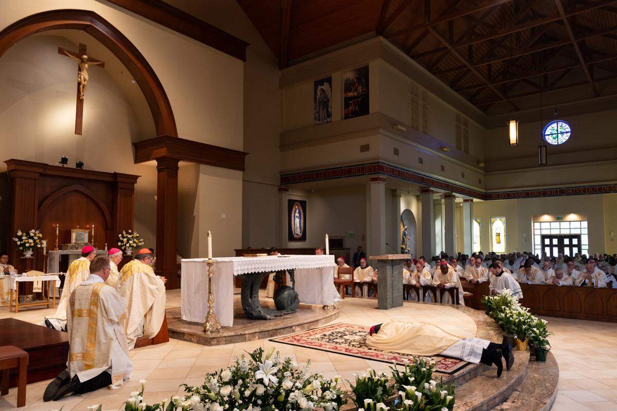 Bishop-elect Michael T. Martin lays prostrate in front of the altar during the ordination ceremony at Saint Mark Catholic Church in Huntersville on May 29, 2024.