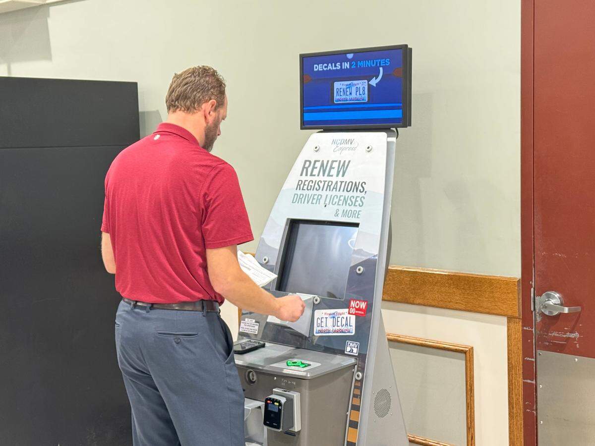NCDMV Communications Director Marty Homan demonstrates how to complete a vehicle registration renewal transaction at a kiosk in Charlotte in August 2024.