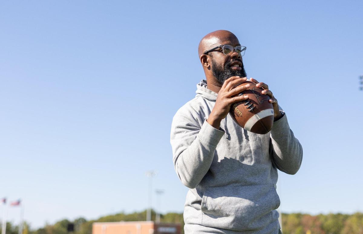 Palisades football coach Jonathan Simmons passes a ball for.a portrait at Palisades High School in Charlotte, N.C. on Tuesday, October 15, 2024.