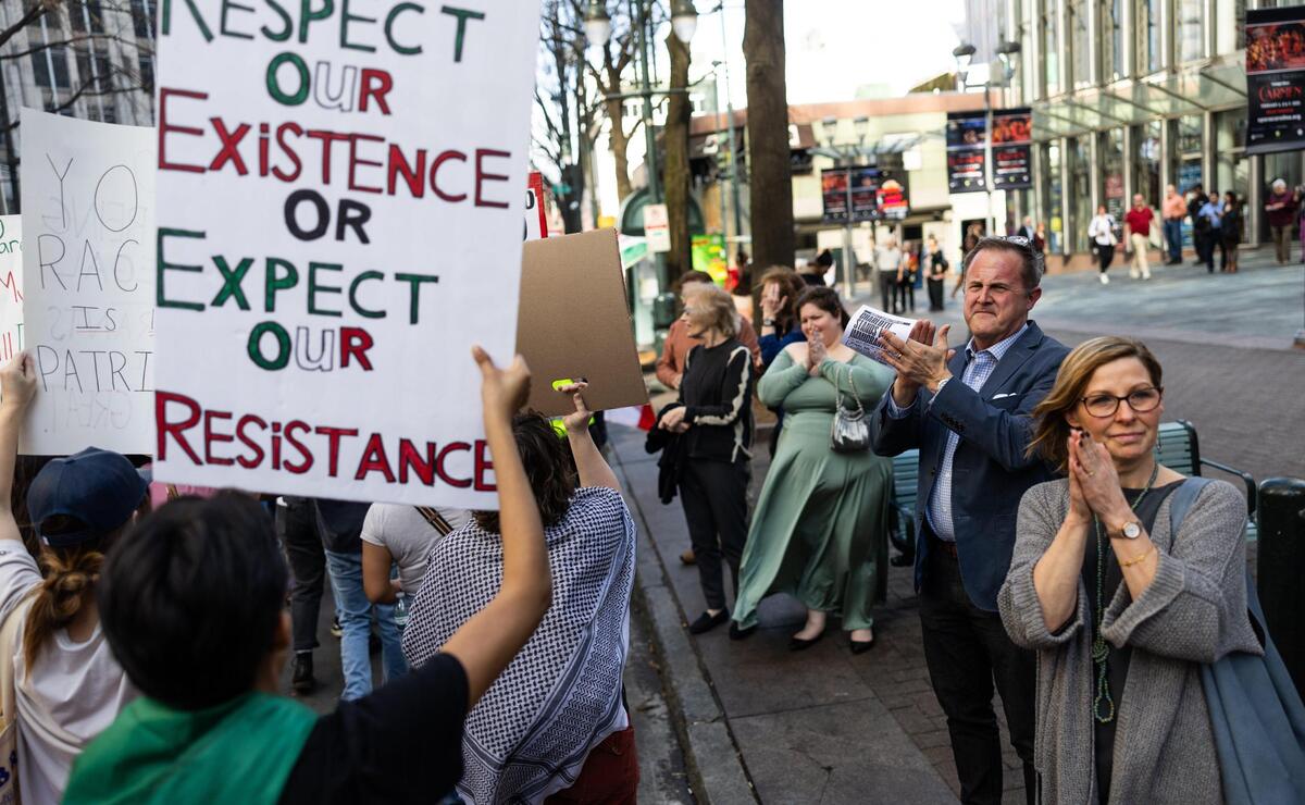Bystanders stop to clap and cheer during a “Stop the Deportations” protest in Charlotte on Sunday.