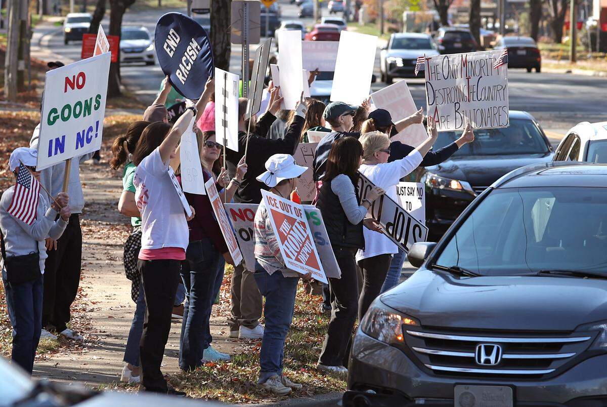Protesters stand along North Wendover Road near the Home Depot in Charlotte on Wednesday, November 19, 2025. 