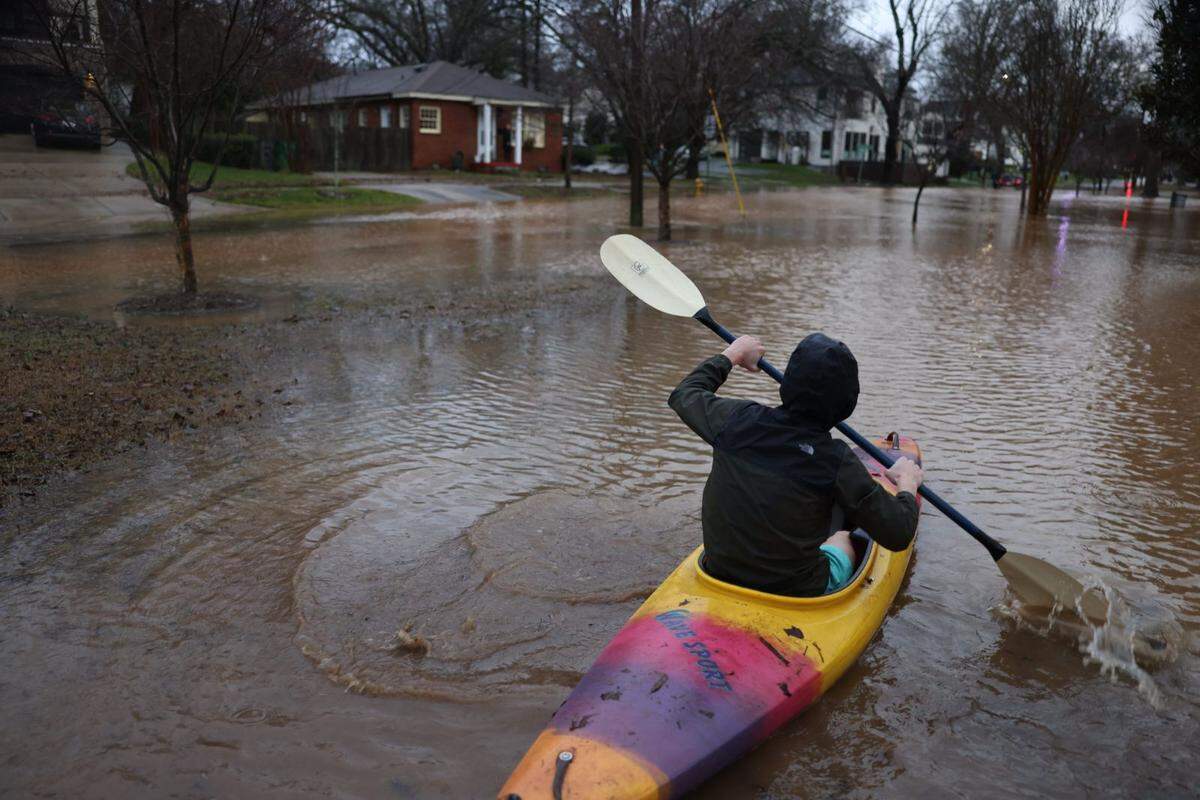 A man uses a kayak at the corner of Ridgewood Avenue and Westfield Road in Myers Park in Charlotte, N.C., on Tuesday, Jan. 09, 2023. Heavy rain in the region led to discolored water in the Rock Hill area.