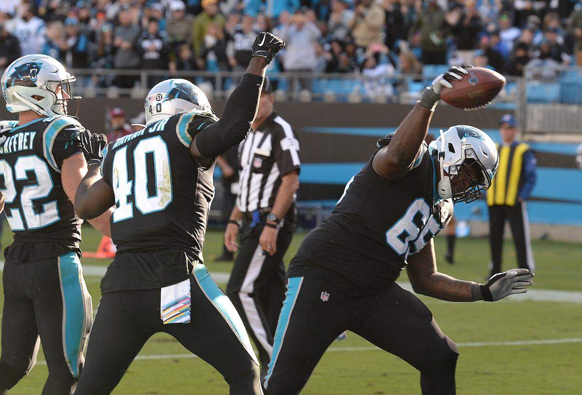 Carolina Panthers tackle Dennis Daley, right, spikes the football that running back Christian McCaffrey (22) used to score against Tennessee. Daley, a rookie, is starting at left tackle for the Panthers.